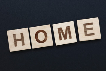 Obraz premium Word HOME on wooden signs over black