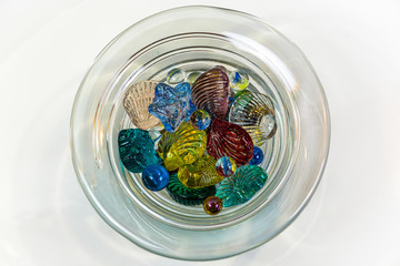 Colorful seashell ornaments made of glass isolated on white back