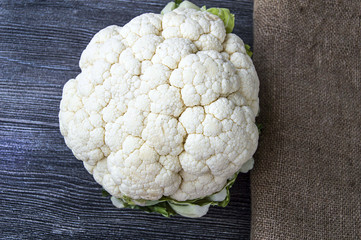cauliflower vegetable, whole cauliflower stands on wooden floor
