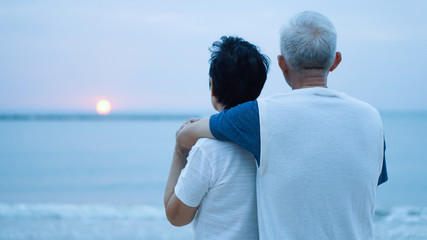 Asian senior couple dating at sunrise sea