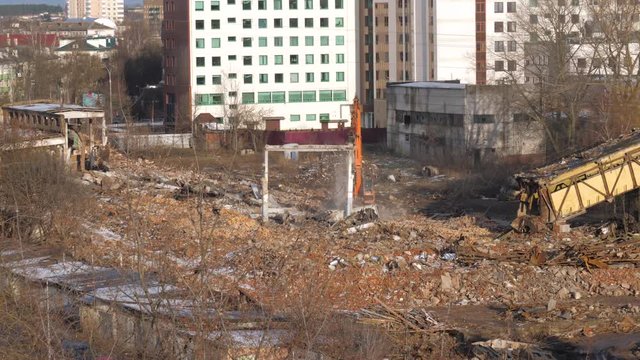 Construction Equipment Is Engaged In The Demolition Of The Walls Of Old Factory