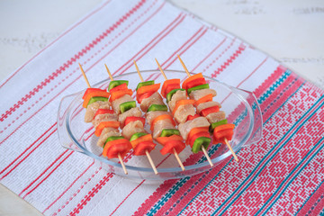 Shish kebab from chicken with pepper on a skewer prepared in an oven on a bright napkin
