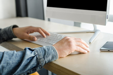 Close up business man top view working personal computer sitting wooden table desktop office window skyscraper. Male hands using smart phone typing computer keyboard. Young entrepreneur working 