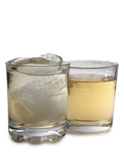 Glass jars with whiskey and ice on white background