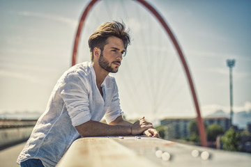 One handsome young man in urban setting in European city, standing