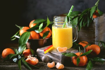 Freshly squeezed orange juice in a mason jar with fresh mandarins.
