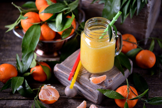 Freshly squeezed orange juice in a mason jar with fresh mandarins.