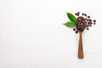 Coffee beans. On a spoon lie on a wooden background. Top view. Copy space.