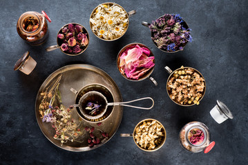 Dried medical healing herbs and herbal tea in metal cups