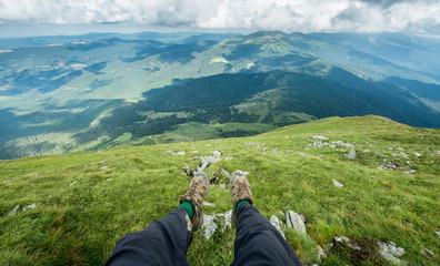 legs of the traveler in hiking boots in the mountains 