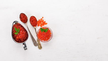 Red salmon caviar. On a wooden background. Top view. Free space for text.
