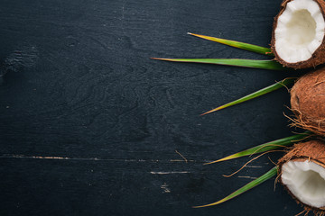 Coconut on a wooden background. Tropical fruits and nuts. Top view. Free space for text.