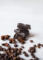 Close up of annis and dark chocolatea on white wooden table.