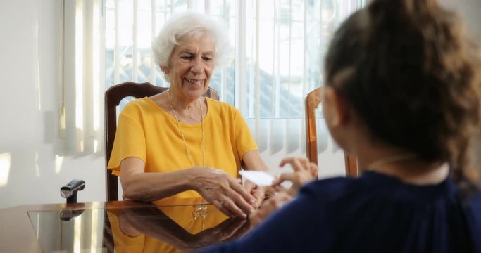 Grandchild And Grandma Playing Magic Tricks With Cards At Home