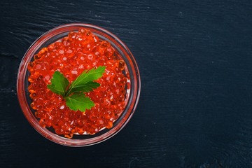 Red salmon caviar. On a wooden background. Top view. Free space for text.