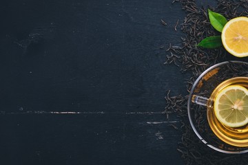 Tea in a glass cup with spices and herbs. On a black wooden background. Top view. Copy space.