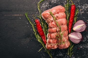 Raw meat Beef fillet with rosemary and spices on a black wooden background. Top view. Free space...