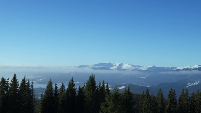 Winter landscape in Carpathians mountains and cloudy blue sky. Camera panning to the right