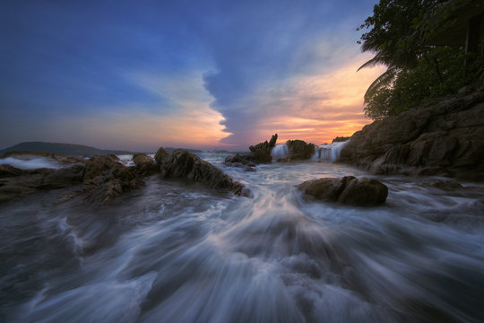 Beautiful seascape with heavy motion wave waterfall and sunset at Kalim Beach in Phuket, Thailand.