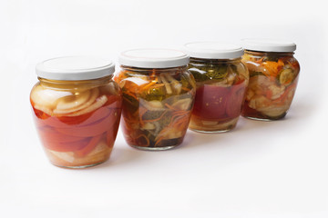 Fototapeta na wymiar Bright glass jars with homemade vegetable salad isolated on white background