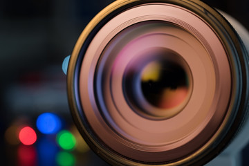 The photo or videocamera lens on dark background with lense reflections