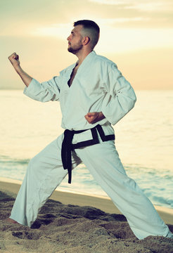 Brunette guy practising karate kata poses