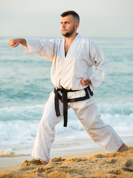 Smiling male practising karate kata poses