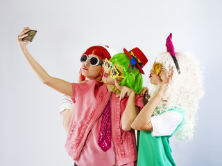 Cheerful maiden company makes selfies. White background.