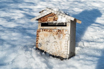 Old rusty metal Mailbox on the snow.
