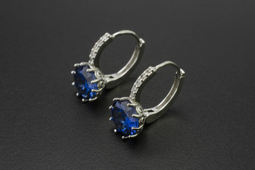 silver earrings with diamonds and sapphires isolated on black