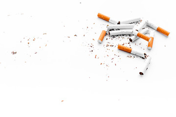 Smoking. Half-smoked cigarettes with ash on white background top view copy space