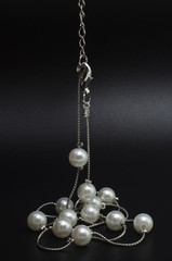 silver necklace chain with pearls isolated on black