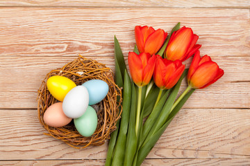 Easter Eggs in a birds nest with colorful tulips