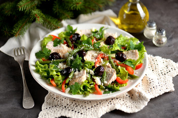Healthy salad from boiled chicken breast with salad lettuce, red pepper, dried olives, green beans, parsley, parmesan cheese, olive oil and balsamic vinegar.