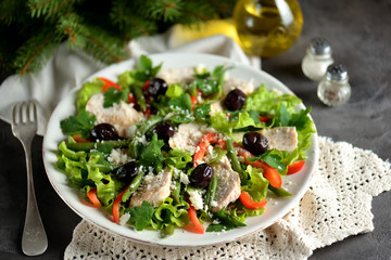Healthy salad from boiled chicken breast with salad lettuce, red pepper, dried olives, green beans, parsley, parmesan cheese, olive oil and balsamic vinegar.