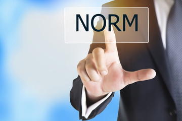 Businessman hand touching NORM button on virtual screen