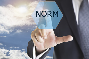 Businessman hand touching NORM button on virtual screen