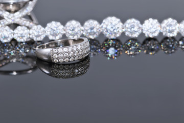 Silver bracelet with many sparkling diamonds and elegant ring with precious stones
