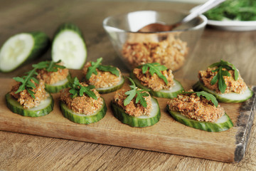 Raw sunflower seed & sun-dried tomato pesto or dip on cucumbers. Homemade vegan snack with vegetables.