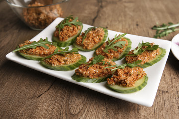 Raw sunflower seed & sun-dried tomato pesto or dip on cucumbers. Homemade vegan snack with vegetables.
