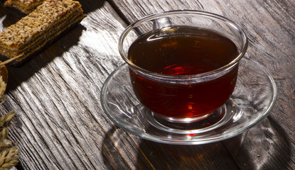 A cup of hot herbal tea and cookies on the old wooden background