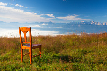 Old wooden chair on the top in Carnic Apls in Austria.