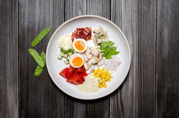 Top View Healthy Hearty Cobb Salad with Chicken, Bacon, Tomato, Onions, Eggs, green beans. American food. Close up, home made