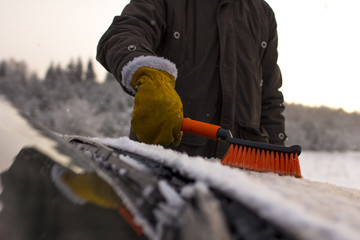 a man, cleans a car from snow