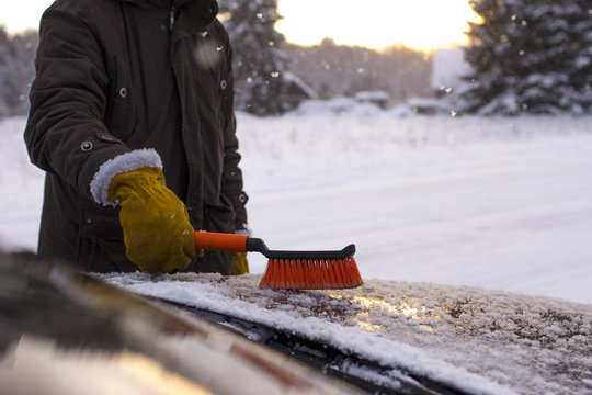 a man, cleans a car from snow