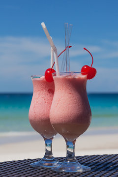 Two tropical coctails on a wattled table against the turquoise sea, Redang island, Malaysia