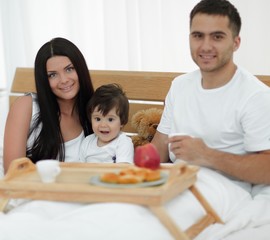 Family having breakfast in bed at home
