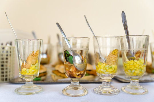 Various party snacks in glasses on a buffet