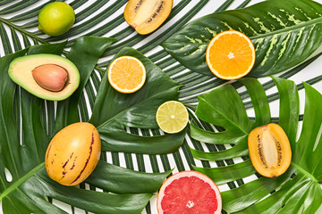 Creative Tropical Layout. Palm Leaves and Fresh Fruits. Colorful Summer Design Set. Healthy Art Food concept. Nature Bright Summer background. Flat lay.