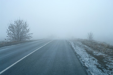 The car in thick fog with fog lights.